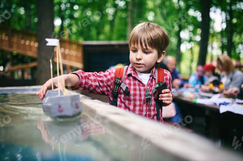 Preview: Outdoors portrait of cute preschool boy playing homemade ship in the park