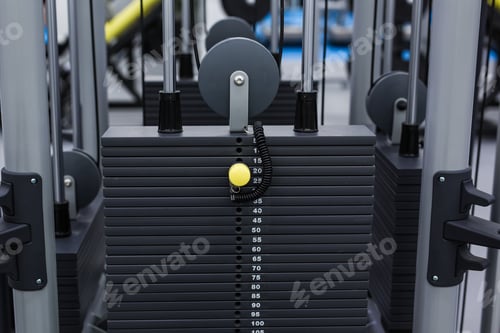 Preview: Black iron heavy plates stacked of weight machine in fitness gym. Sports simulator plates