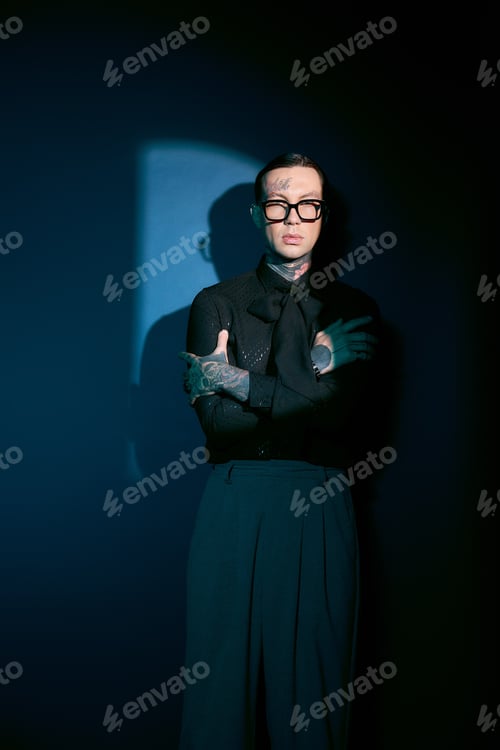 Preview: Handsome young man showcases unique style against a dramatic blue backdrop