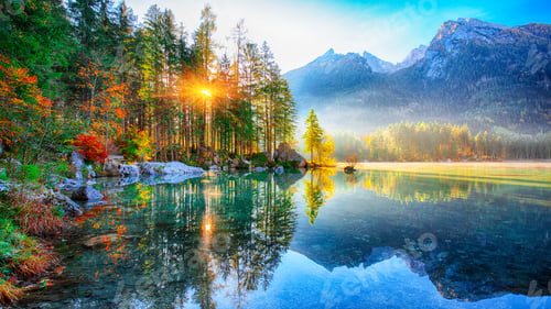 Preview: Beautiful autumn sunrise scene with trees near turquoise water of Hintersee lake