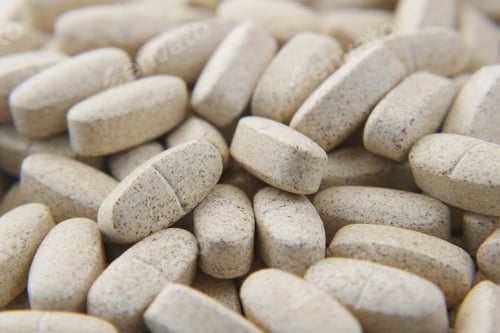 Preview: white color medical pills spilling on pink