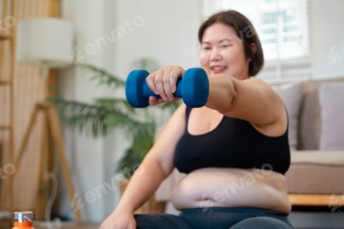 Preview: Plus-size woman lifting a dumbbell with a smile, promoting strength and healthy lifestyle at home