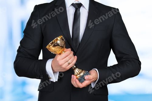 Preview: Businessman holding golden cup trophy