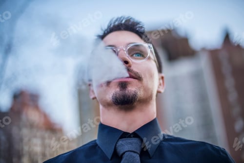 Preview: Young man outdoors, exhaling smoke