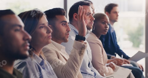 Preview: Shot of a young businessman raising his hand during a conference in an office