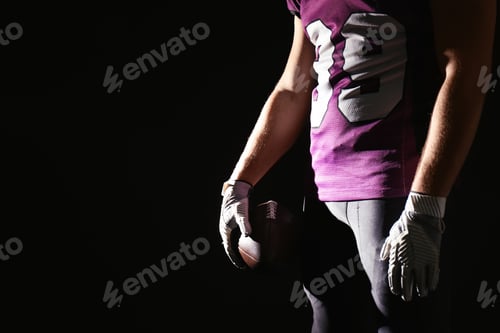 Preview: American football player with ball on dark background, closeup. Space for text