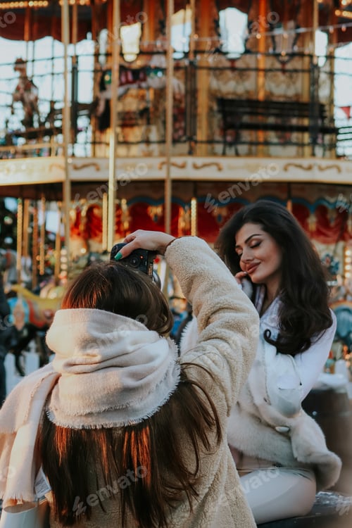 Preview: Girl snapping photos to her friend with a beautiful christmas background