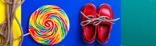 Preview: Banner with Small red boat shoes near big multi-colored lollipop and rope on colored background.