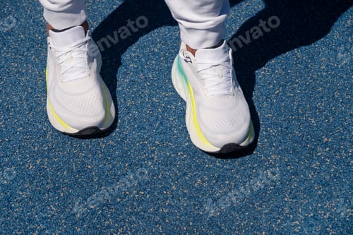 Preview: Athlete legs in white sneakers on outdoor sports ground. Workout. Close up. Outdoors.