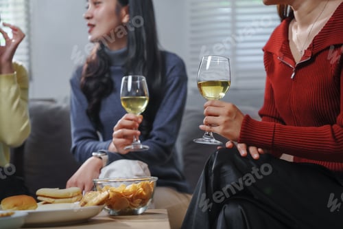 Preview: Friends enjoying wine and snacks during a relaxing home party