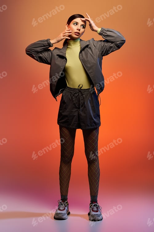 Preview: Fashionable young woman showcases trendy outfit in stylish studio setting