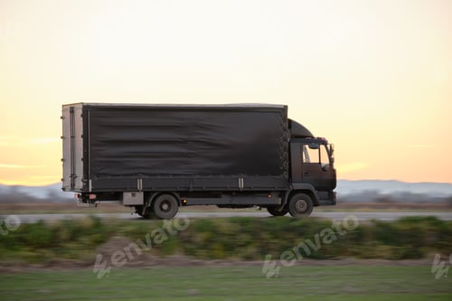 Preview: Cargo truck driving on highway hauling goods in evening. Delivery transportation and logistics