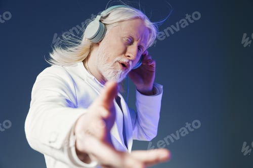 Preview: elderly man enjoying music, relaxed and engaged, wearing headphones, light gray background