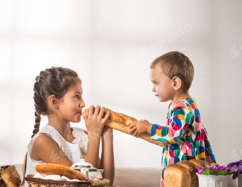 Preview: Funny little children eat fresh bread and rolls