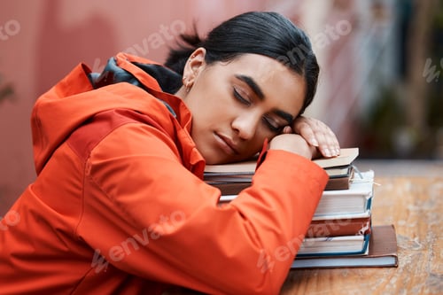 Preview: Ill just close my eyes for a bit. Shot of a young female student sleeping in a library at college.