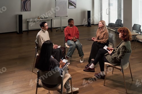 Preview: Diverse Young Adults Sitting in Circle Participating in Group Therapy Session