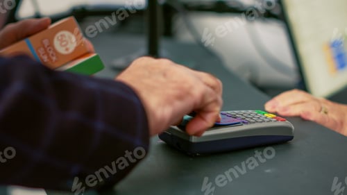 Preview: Male client using credit card on pos to pay for medicine