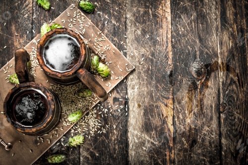 Preview: Beer in a wooden mug with green hops.