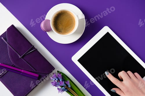Preview: cropped image of woman using tablet at white and purple table