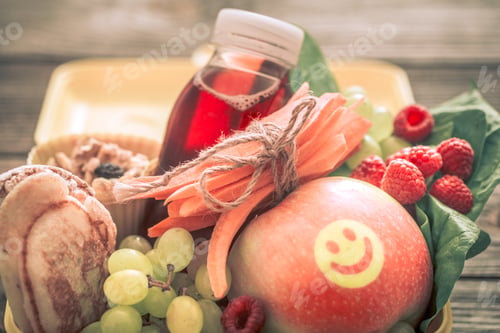 Preview: Breakfast or lunch with healthy food in a yellow box, on a wooden background.