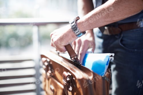 Preview: Businessman putting paperwork in briefcase