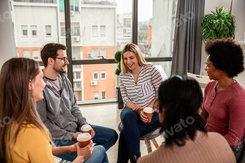 Preview: Diverse group of people sitting in circle in group therapy session.