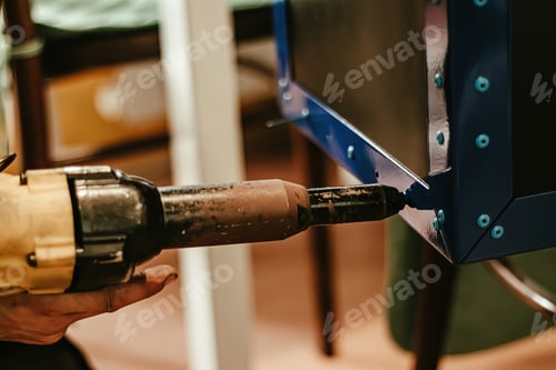 Preview: Male worker uses electric riveting gun. Hand holding riveting m
