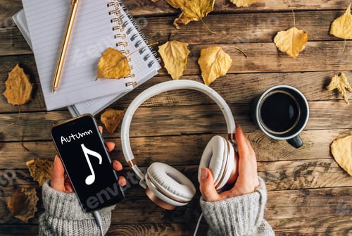 Preview: Headphones with autumn dry leaves, cuo of coffee and notepads on rustic wooden background