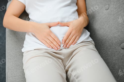 Preview: Young woman suffering from menstrual cramps at home. Gynecology