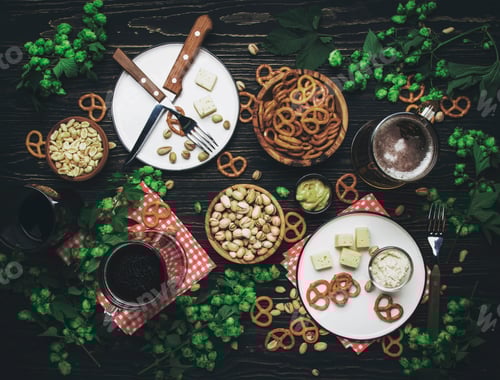 Preview: Light and dark beer in mugs and salty snacks and nuts