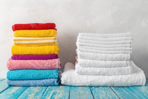 Preview: Stack of bath towels on wooden table with copy space
