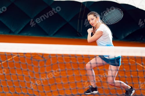Preview: Attractive woman tennis player waiting for service at indoor court