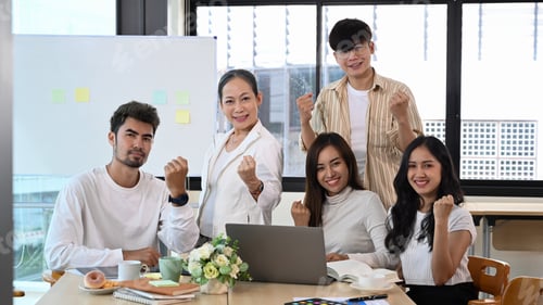 Preview: Successful mature businesswoman and team cheering with clenched fist, celebrating corporate.