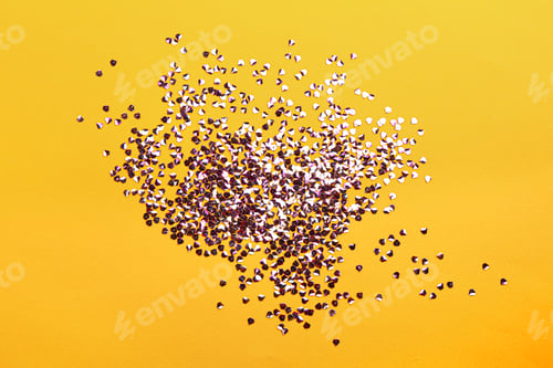 Preview: Shiny bright violet glitter on yellow background, flat lay