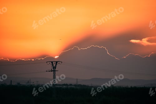 Preview: impressive sunset behind the clouds and the electricity towers one day with the orange sky, albufera