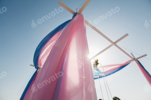 Preview: Wedding arch pink color on the background of the sea.