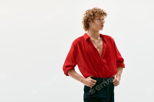 Preview: Elegant young man showcases bold style in vibrant red shirt within a modern studio