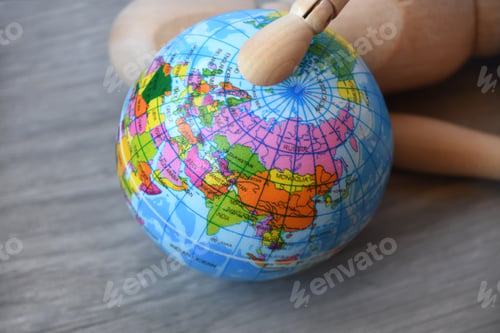Aperçu: Tired wooden human figure lying on the floor and holding globe planet Earth. World Financial crisis