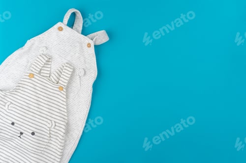 Preview: Top view of baby clothes on blue background
