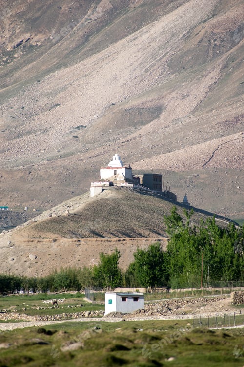 Preview: Single monastery on the side of a mountain with lush trees in the foreground