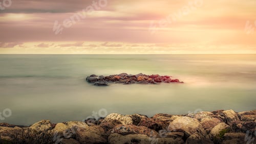 Preview: Aerial view of sea with rocky beach at sunset