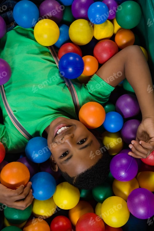 Preview: Overhead view of happy boy in ball pool