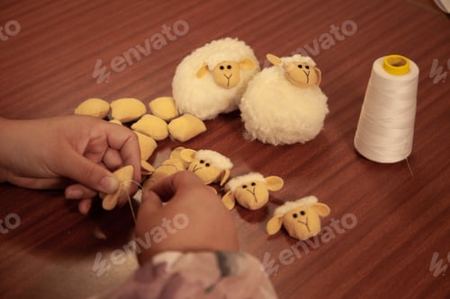 Preview: A woman sews a stuffed sheep with her hands.