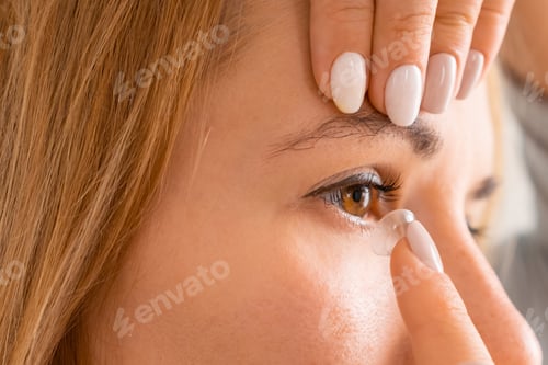 Preview: Smiling woman applying contact eye lenses