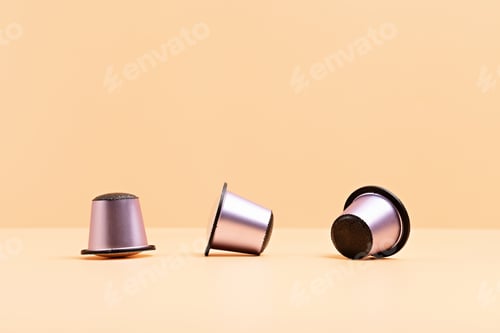 Preview: Disposable coffee capsules over beige background with copy space. Morning dose of caffeine, energy