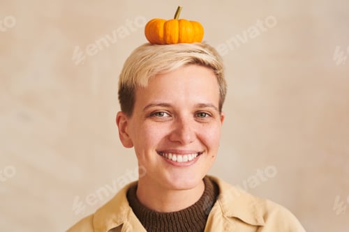 Preview: Playful woman with small pumpkin on head