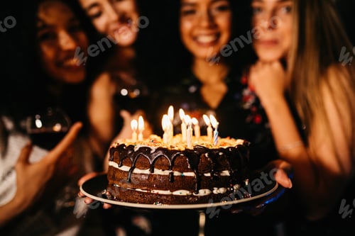 Preview: Close up shot of woman holding birthday cake standing indoors with friends