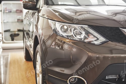 Preview: The headlights and the hood of a black luxury car
