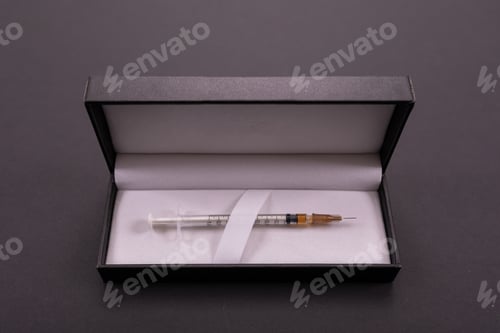 Preview: white syringe in a black cover isolated on background