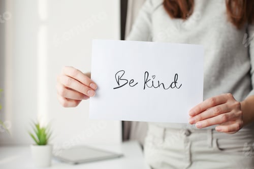 Preview: Words in the wild, message "be kind" on the white sheet of paper, hands, holding a sign, positive